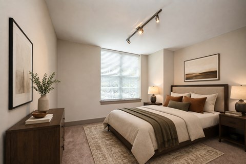 A bedroom with a large bed and a window with blinds.