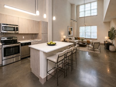 A modern kitchen with a large island and stainless steel appliances.