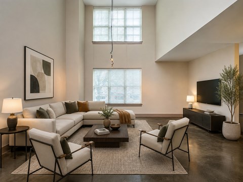 A modern living room with a white sofa, a coffee table, and a TV.