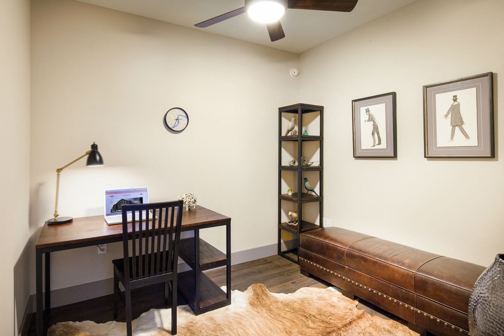 a home office with a leather couch and a desk