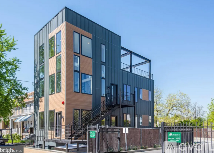 A modern multi-story building with a combination of wood and glass panels.