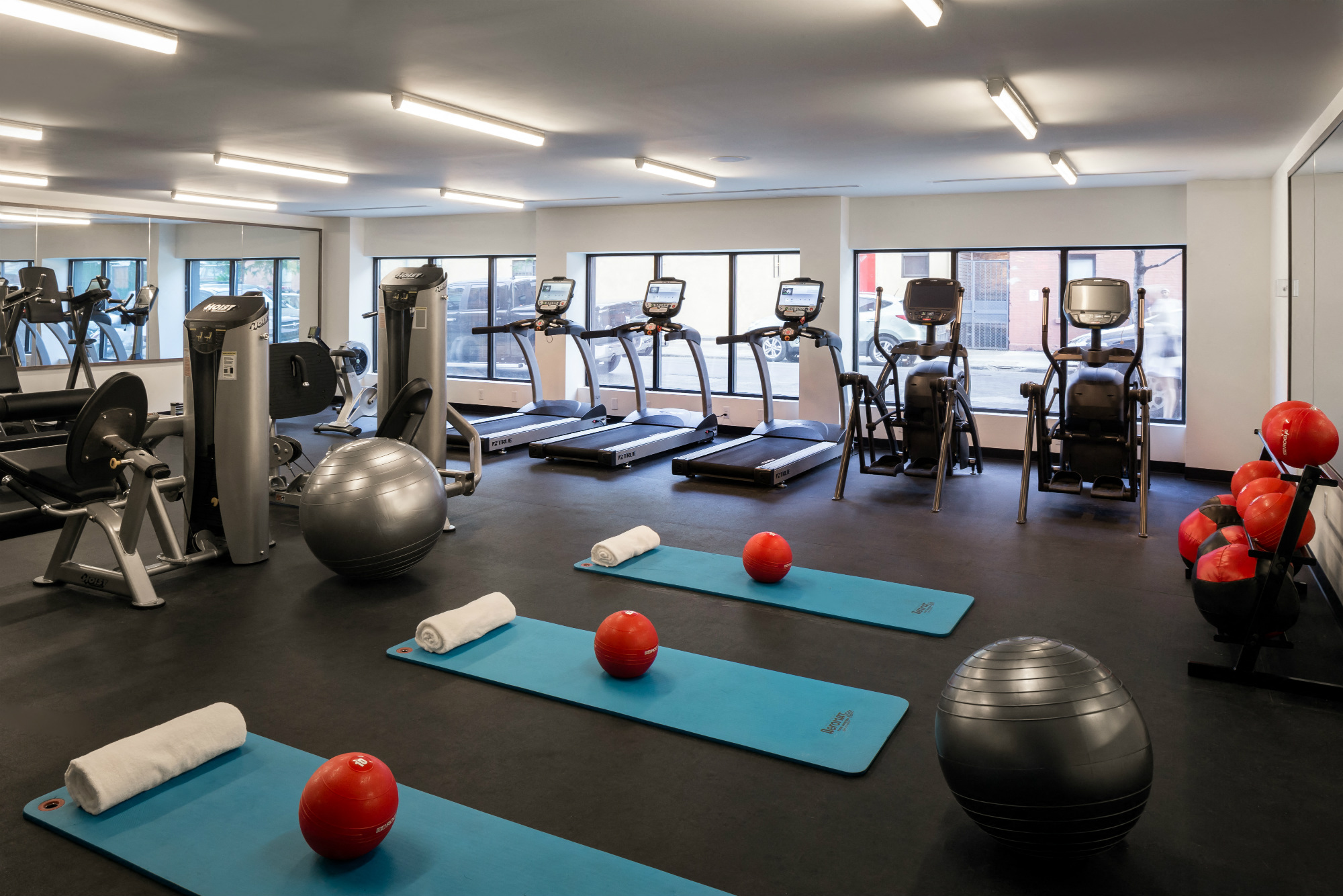 a gym with exercise equipment and yoga mats