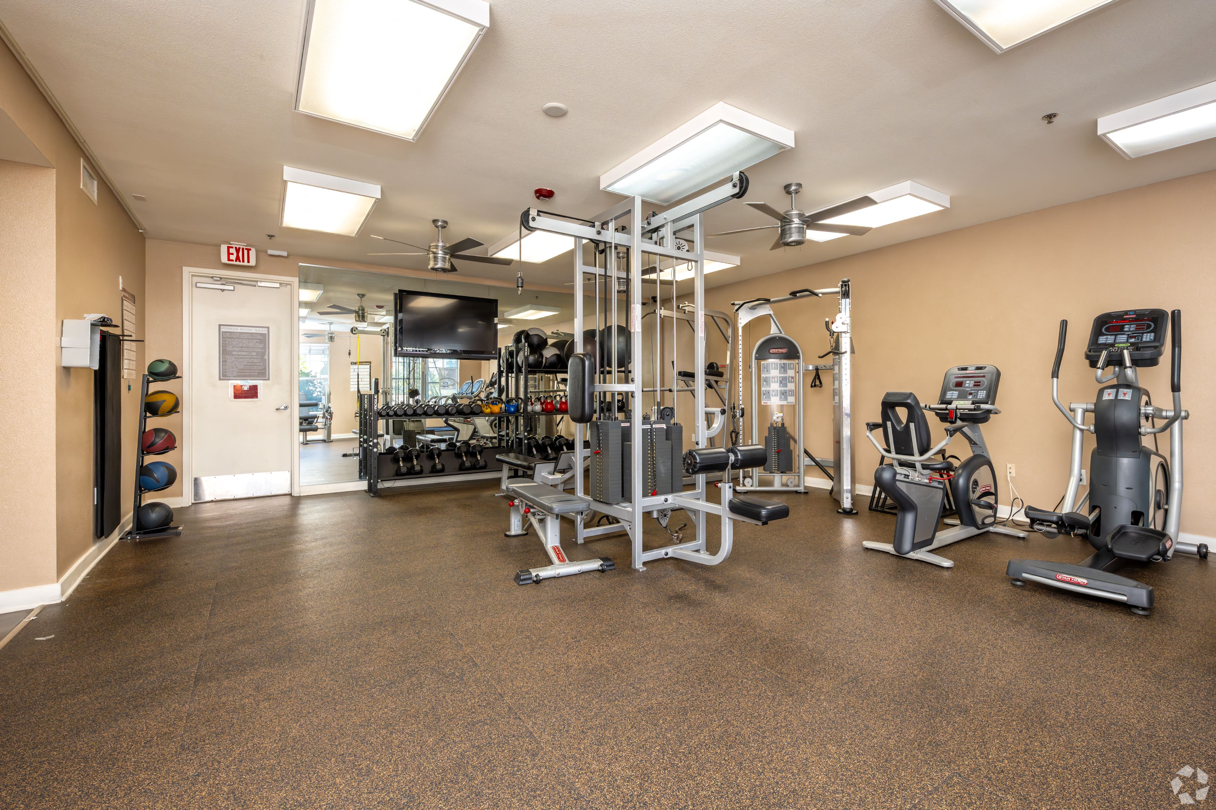 A gym with a variety of equipment including weights, a treadmill, and a stationary bike.