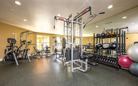 A gym with a variety of equipment including weights and machines.