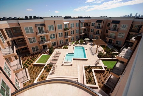 A large apartment complex with a pool and landscaped courtyard.