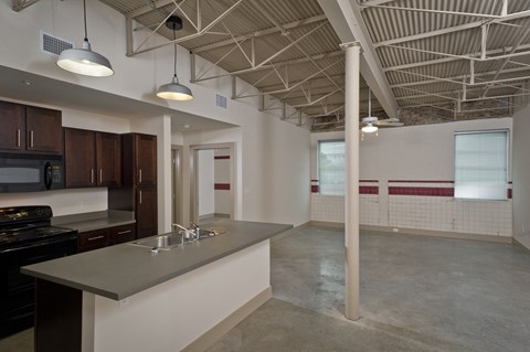 an open kitchen and living room in a building with exposed ceilings
