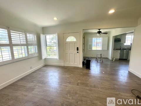 A spacious room with a door, a fan, and a window.