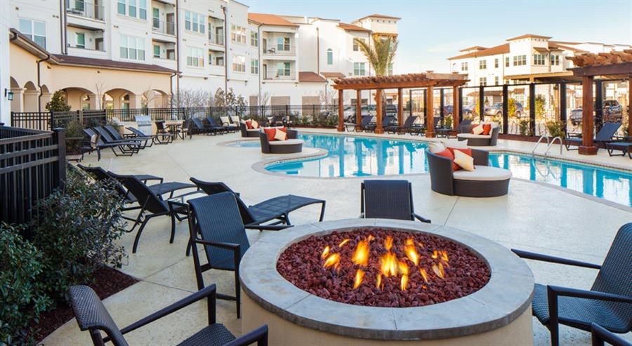 a swimming pool with chairs and a fire pit