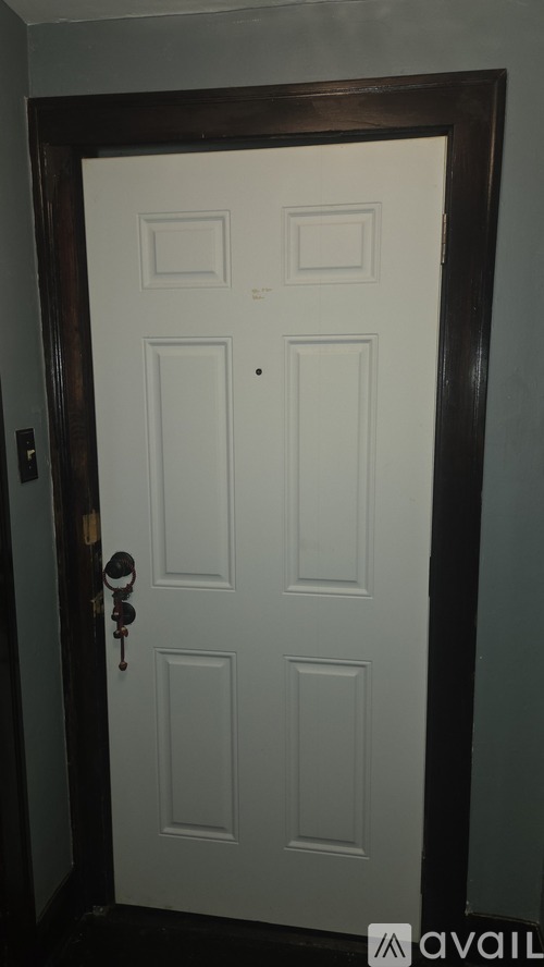 A white door with a key in the lock.