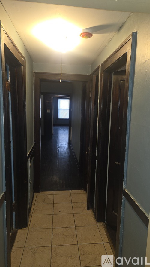 A long hallway with doors on both sides and a light hanging from the ceiling.