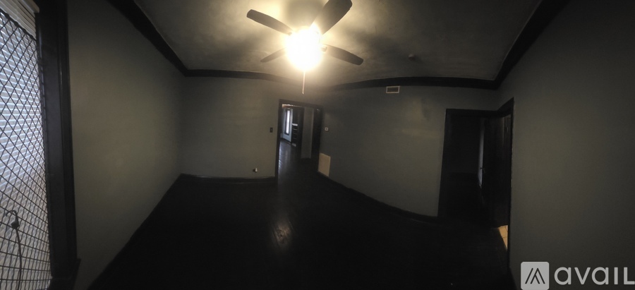 A dark room with a fan and a light on.