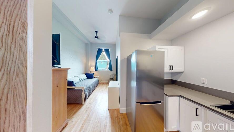 A kitchen with a refrigerator, sink, and cabinets.