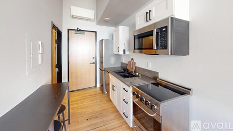 A kitchen with a black countertop and stainless steel appliances.