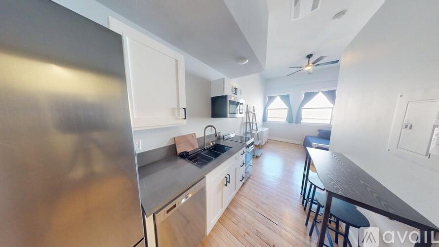 A kitchen with a refrigerator, sink, and stove.