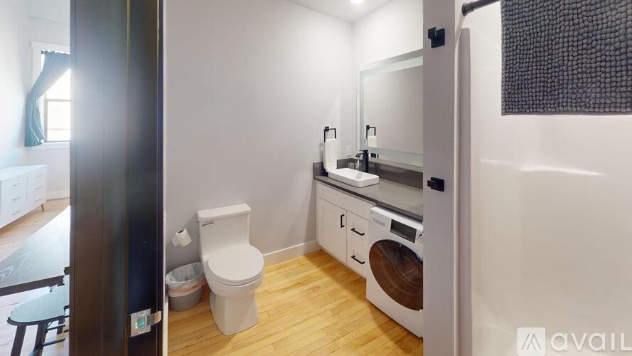 A bathroom with a toilet, sink, and a washer and dryer.