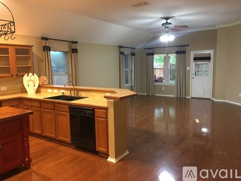 A kitchen with wooden cabinets and a black dishwasher.