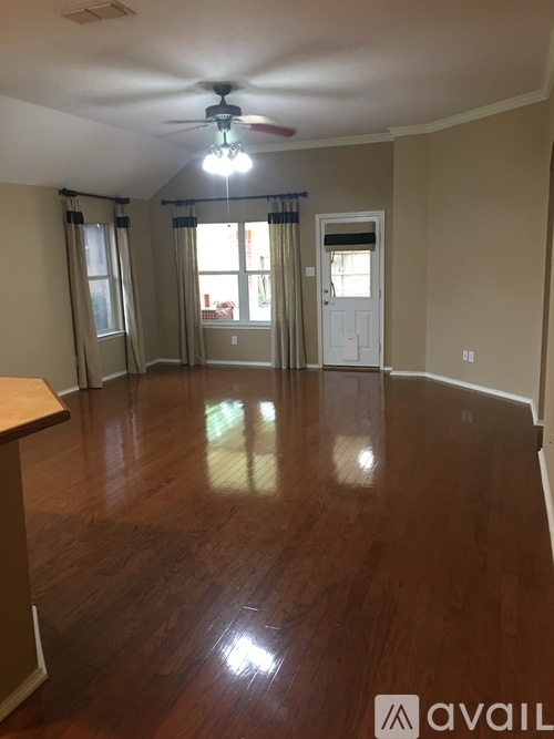 A room with wooden floors and a ceiling fan.