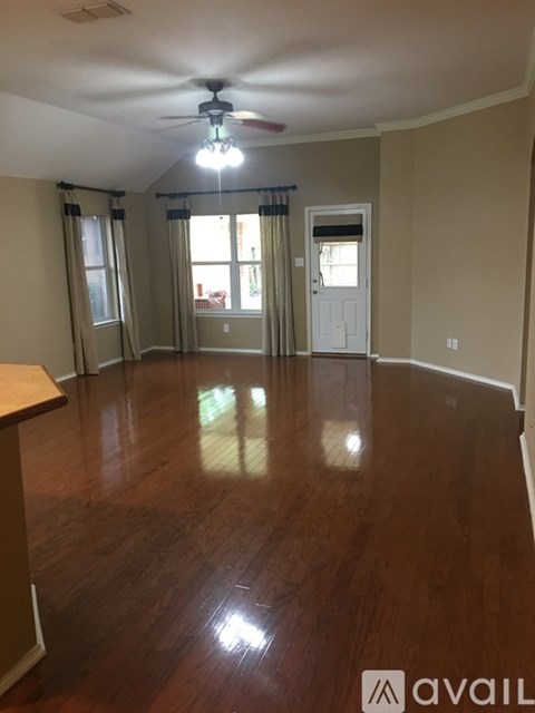 A room with wooden floors and a ceiling fan.