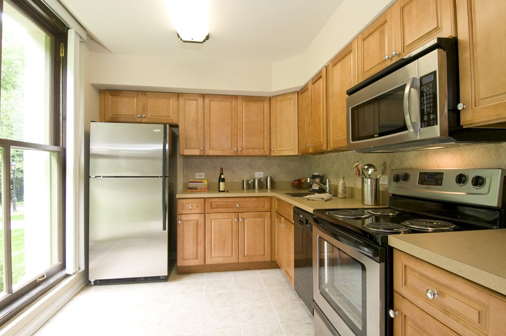 a kitchen with wooden cabinets and stainless steel appliances