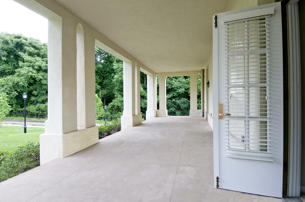 a long porch with white shutters and a white door