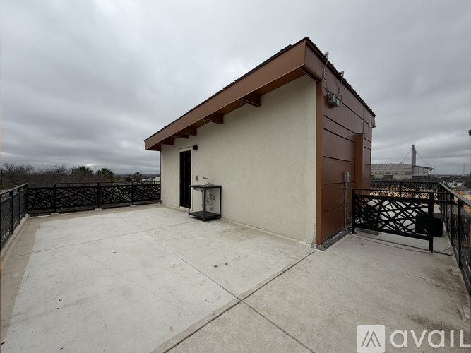 A small building with a brown roof and a black gate in front.
