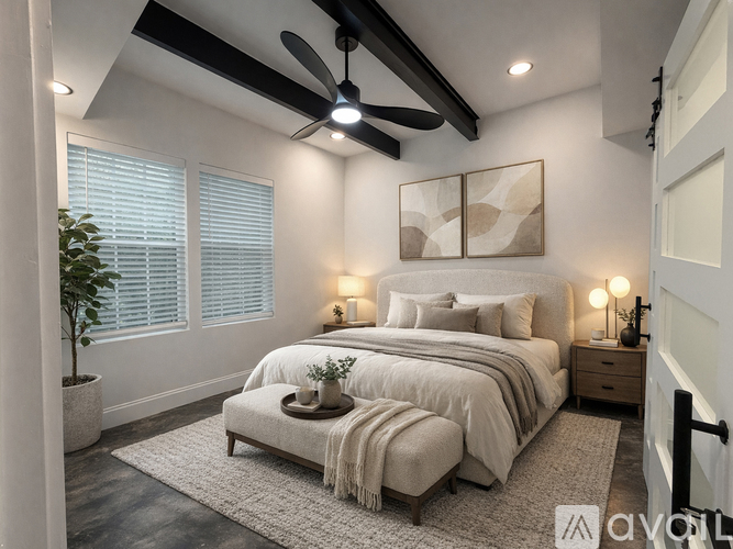A bedroom with a large bed, a ceiling fan, and a potted plant.