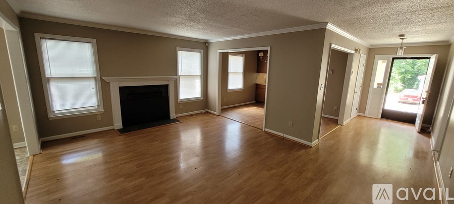 A living room with a fireplace and wood floors.