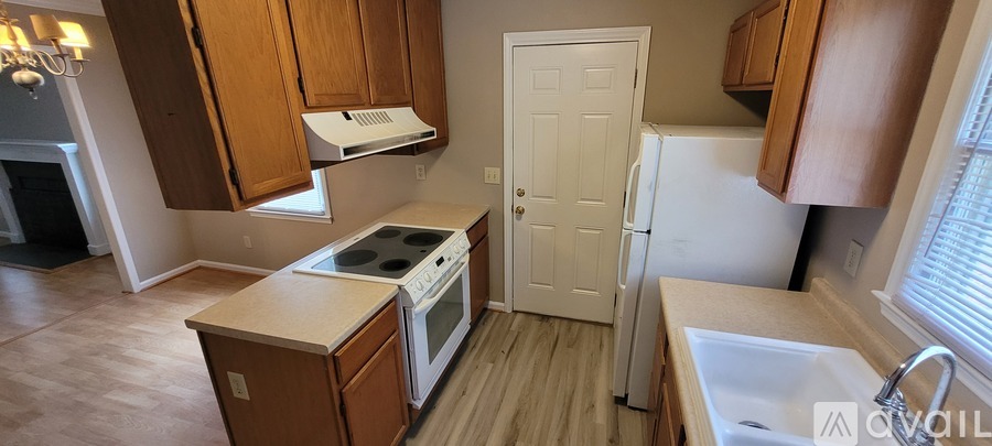 A kitchen with a white fridge and wooden cabinets.