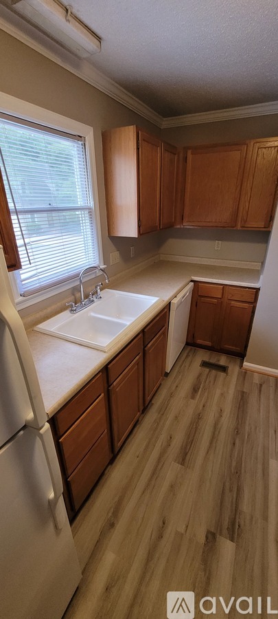 A kitchen with wooden cabinets and a white fridge.
