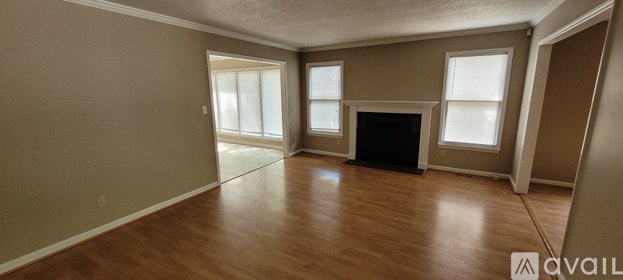 A living room with a fireplace and a large window.