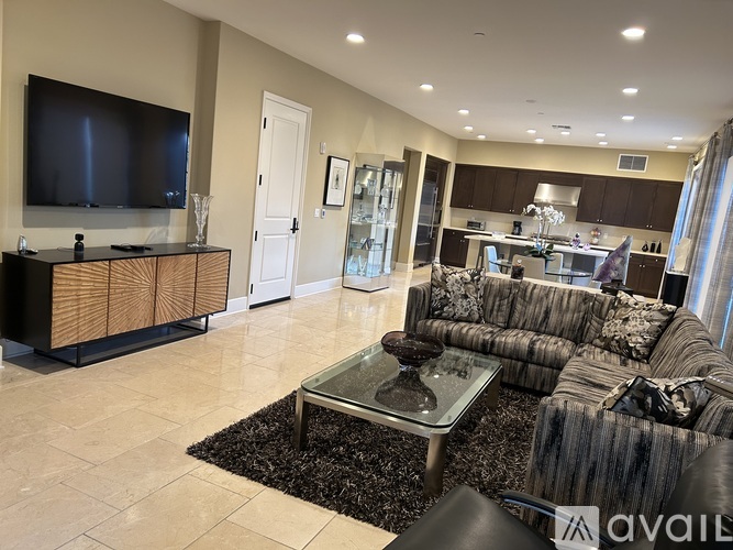 A modern living room with a black and white striped couch and a glass coffee table.