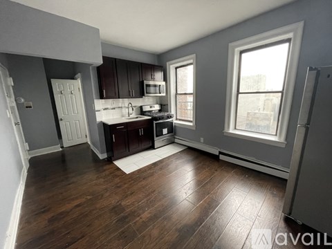 A kitchen with dark wood floors and white appliances.