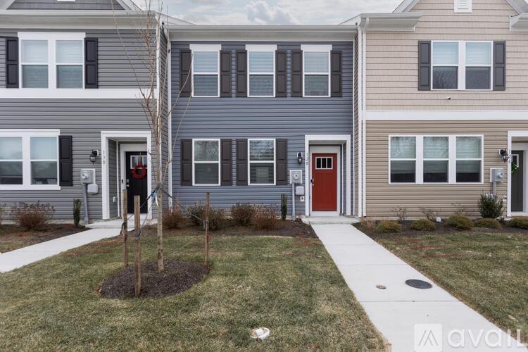 A row of houses with a tree in front of the first one.