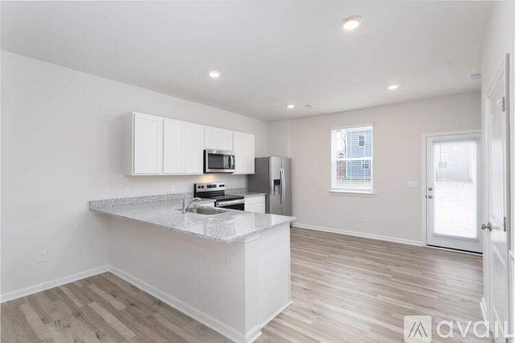 A kitchen with white cabinets and a countertop is shown.