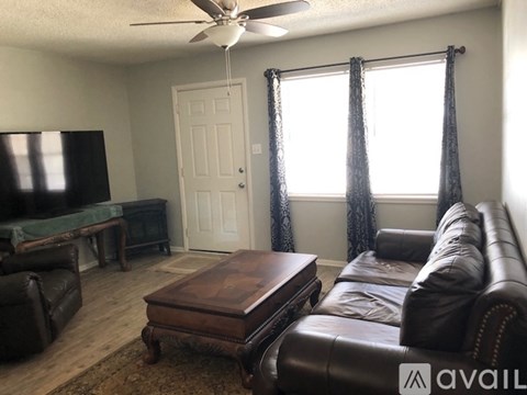 A living room with a brown leather couch and a wooden coffee table.