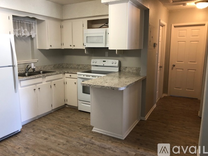 A kitchen with white appliances and cabinets.