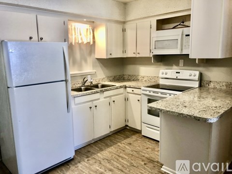 A kitchen with white appliances and cabinets.