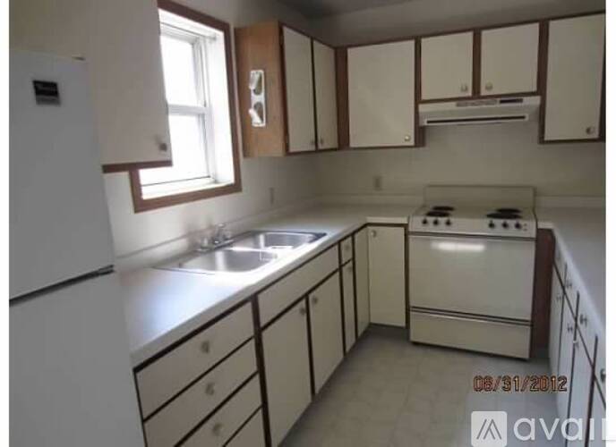 A kitchen with white appliances and wooden cabinets.