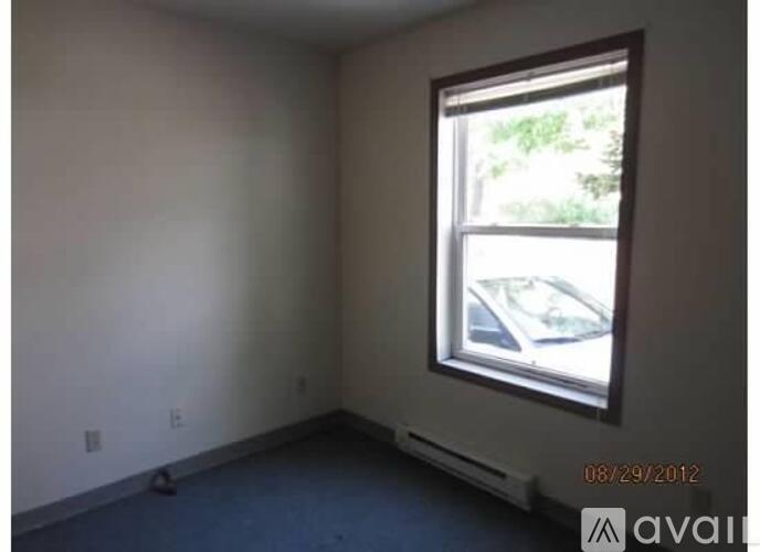 A room with a window overlooking a parking lot.