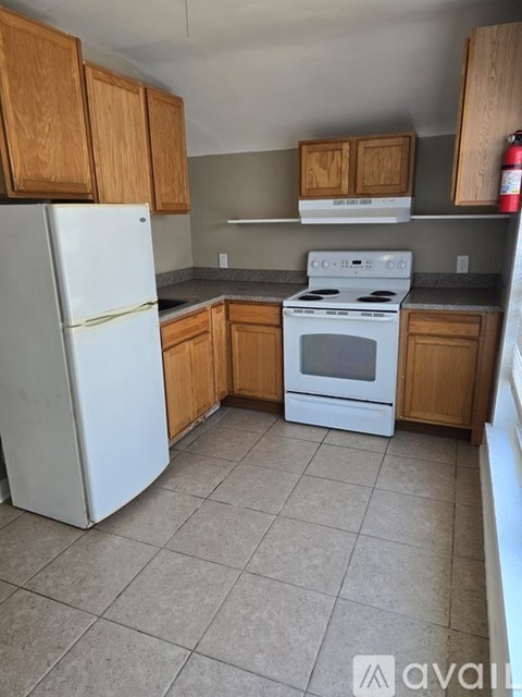 A kitchen with white appliances and wooden cabinets.