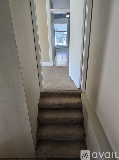 A hallway with a staircase leading to a balcony.