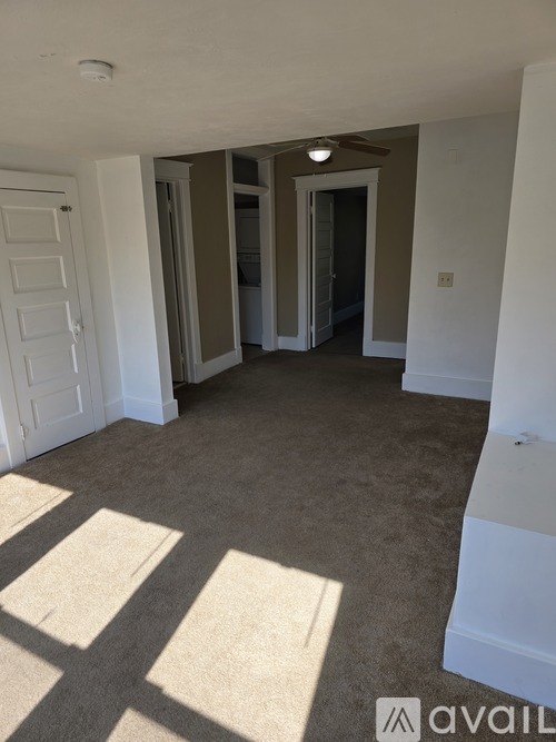 A room with a carpeted floor and white walls.