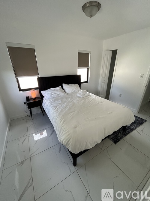 A bedroom with a bed, nightstand, and lamp.