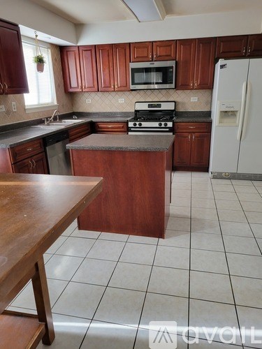 A kitchen with brown cabinets and a white refrigerator.