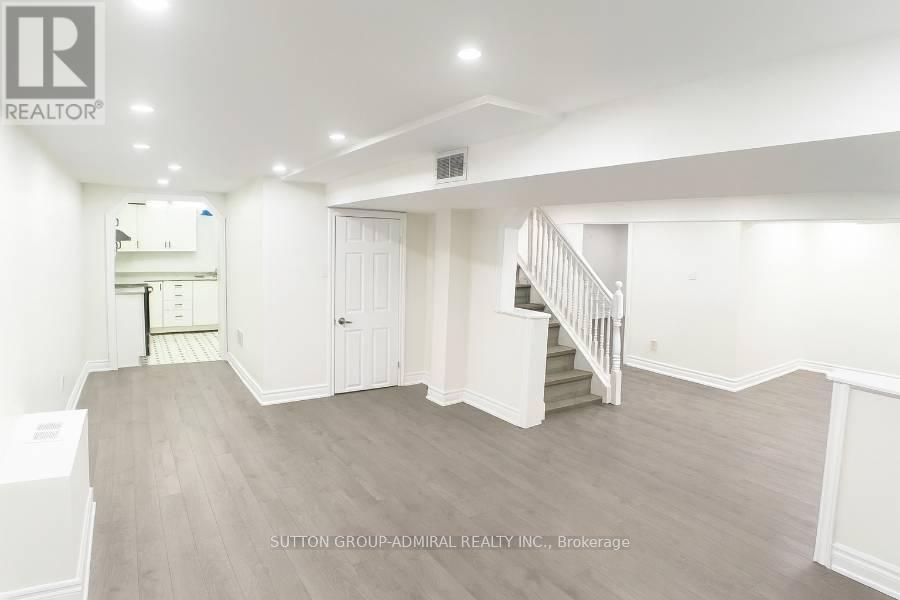A spacious room with a staircase leading to the second floor.