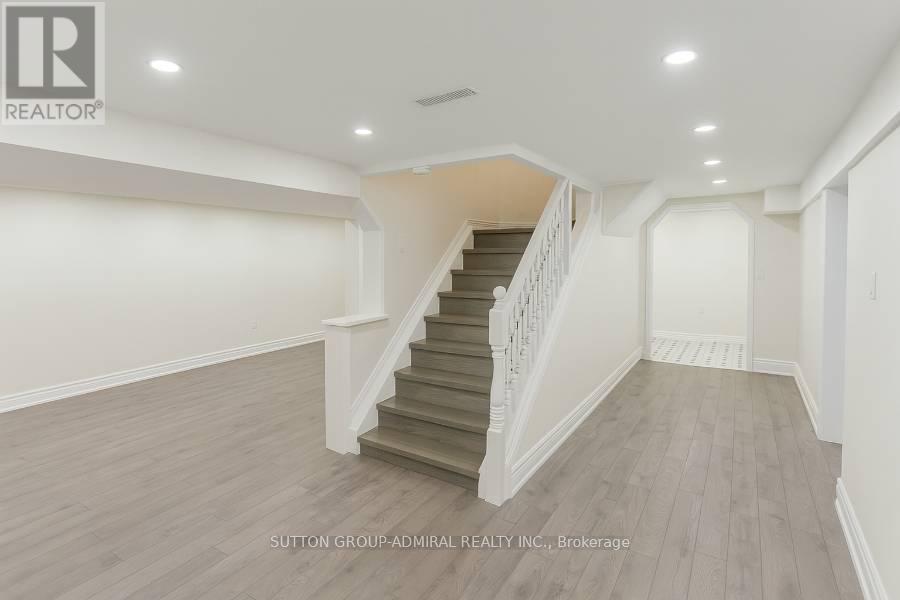 A spacious room with a staircase leading to the upper level.