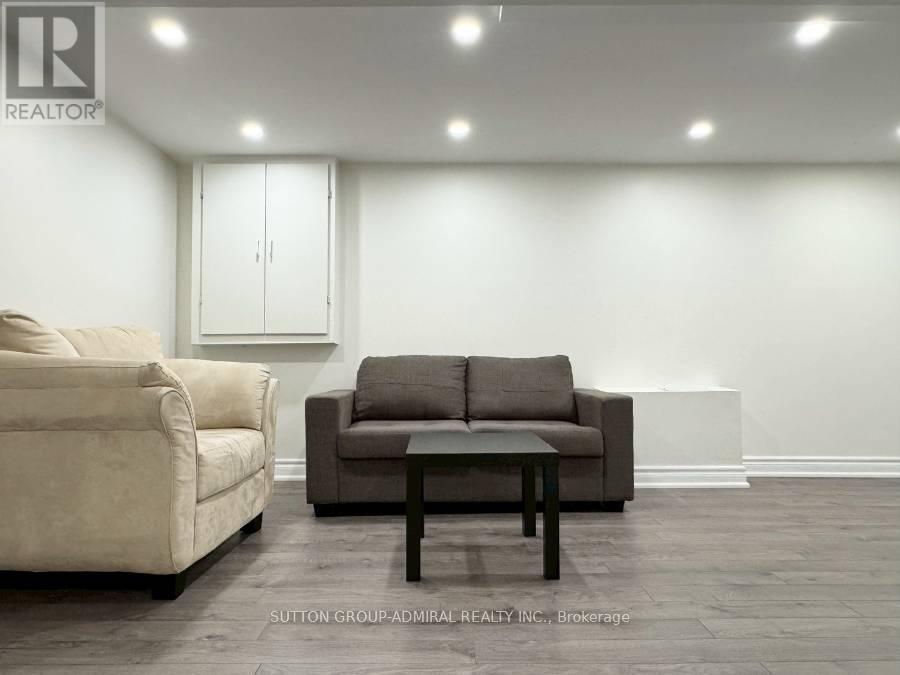 A living room with a beige couch, a brown couch, and a wooden coffee table.
