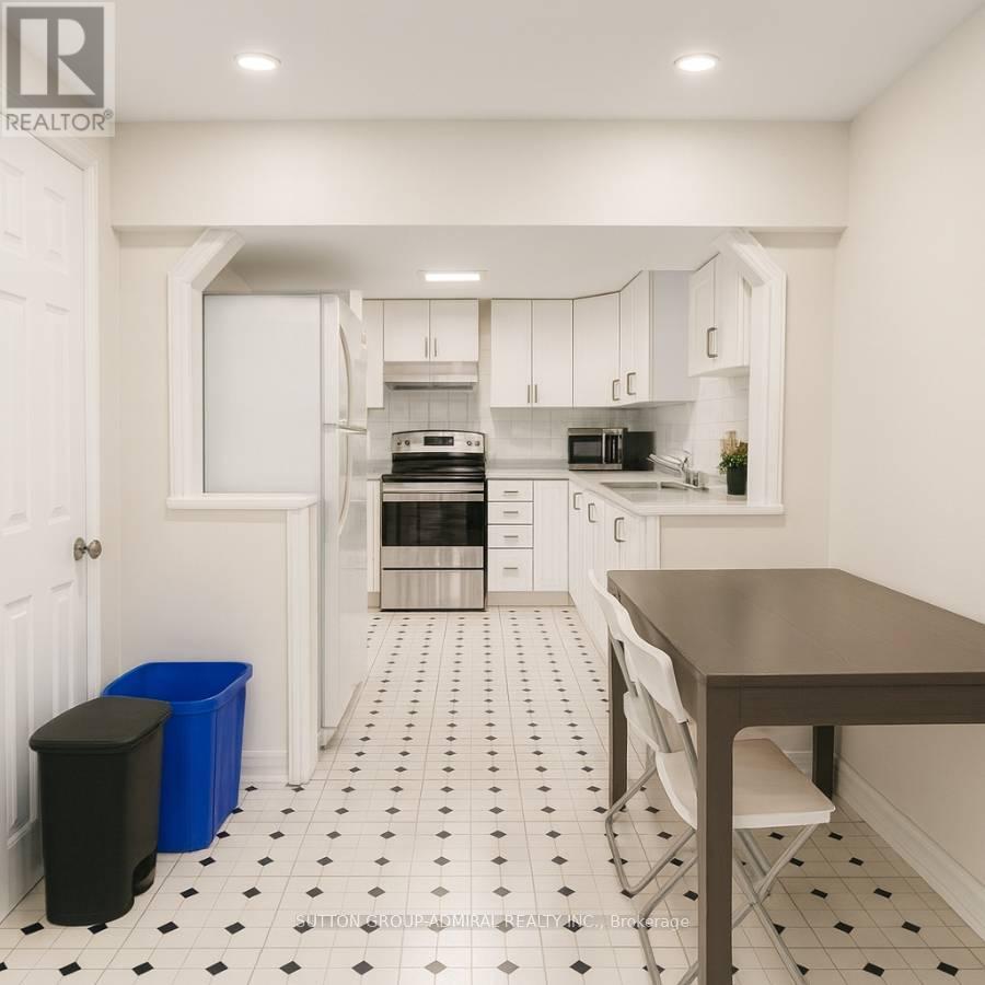 A kitchen with black and white tiles and a brown table.