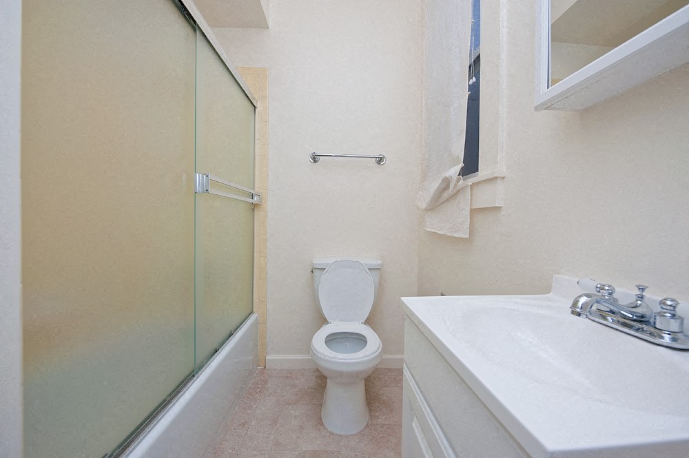 a bathroom with a toilet and a shower and a sink