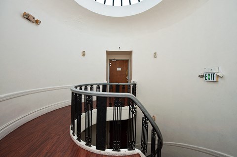 a view of the top of a staircase with a door and a window above it